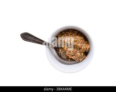 Whole grain dijon mustard in white bowl with old silver spoon isolated cutout on white background Stock Photo