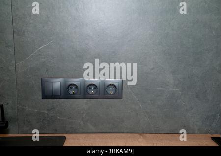 Stylish gray Electric Outlet. Power outlet on the wall. Euro type electric outlet on wall. Stock Photo