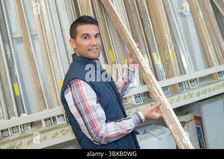 carpenter selecting wood in a hardware store Stock Photo