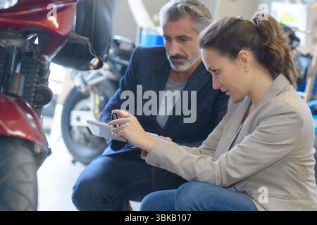 male seller and female client in motorbike store Stock Photo