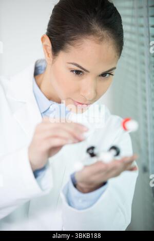 scientist examining dna model in her hand Stock Photo