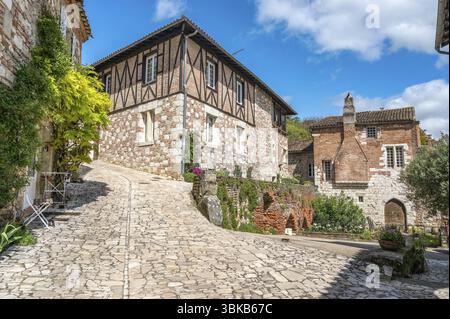 Medieval buildings on Rue de Ferracap with natural stone and brick facades In one of the most beautiful villages in France, Penne-d'Agenais, Departe Stock Photo