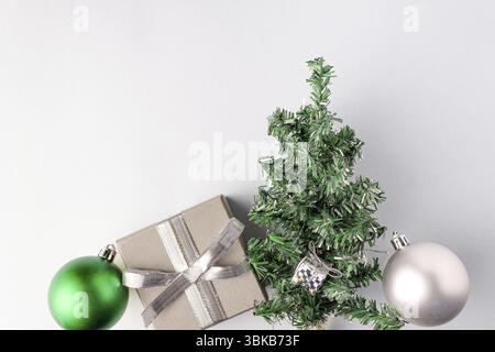 Christmas balls, gift silver box, artificial Christmas tree on a blue background, copy space. Christmas holiday decor Stock Photo