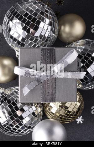 Christmas balls in gold and silver color, gift box on a black background. Christmas holiday decor Stock Photo