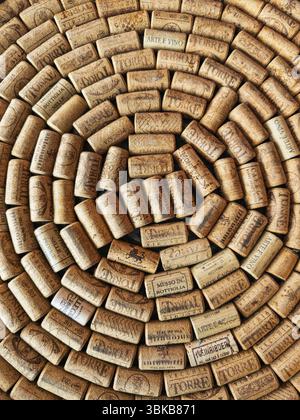 A large number of wine corks laid close together in a spiral pattern. The corks come from different wineries and bear various imprints, logos and lett Stock Photo