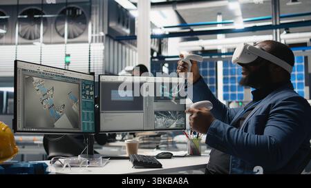 Photovoltaics manufacturing plant analyst works with VR gear to monitor system performance and the solar panels production line. African american expert uses virtual reality. Camera A. Stock Photo