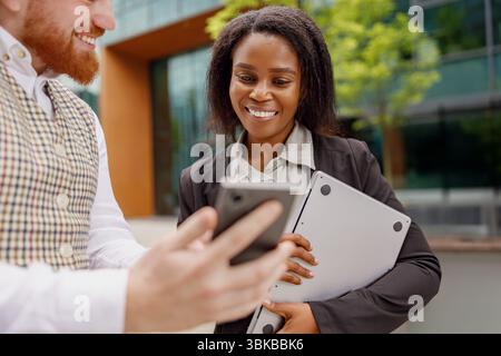 Colleagues are collaborating together outside of their office space using modern technology Stock Photo