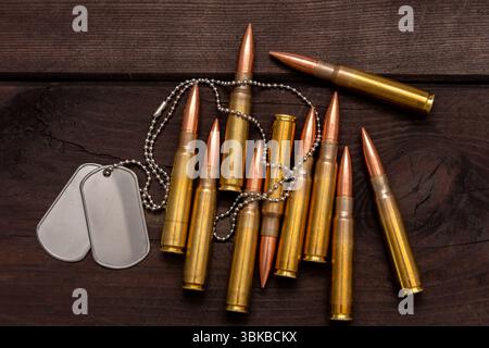 Close-up of army badges and live ammunition against a dark background, symbolising the concept of mercenary and military service Stock Photo