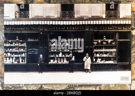 Old postcard from the Museum Four des Casseaux in Limoges shows a photo by Paul Colmar: porcelain merchants in front of the windows of their shop with porcelain figurines and porcelain household goods. Rue Donzelot, Limoges, Nouvelle-Aquitaine, France Stock Photo