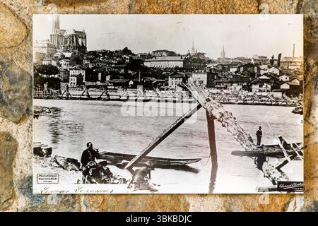 Old postcard from the Museum Four des Casseaux in Limoges shows a photo by Paul Colmar: Harbour workers at Limoges bringing wood ashore. Saint-Etienne cathedral in the background. Rue Donzelot, Limoges, Nouvelle-Aquitaine, France Stock Photo