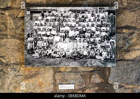 A photograph by Paul Colmar in the Four des Casseaux museum (Musée du Four des Casseaux) on Rue Victor Duruy in Limoges, Haute-Vienne, Nouvelle-Aquitaine, France, shows the group picture with workers in a porcelain factory. Men and boys in work clothes, many of them in caps, stand in tightly packed rows in front of a building, with boys sitting on the ground at the front. The label below names the "Personnel des fours" of the Théodore Haviland manufactory. In English: "Kiln staff". The note "Photothèque Paul Colmar" appears at the bottom right. The museum preserves a porcelain kiln built in 19 Stock Photo