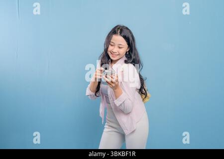 A woman is posing for a picture holding a cell phone. Concept of modern technology and communication Stock Photo