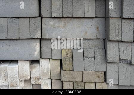 Gili, Lombok, Indonesia - Jan 7, 2025: Pile of gray bricks with a white brick in the middle. The white brick is the only one that is not gray Stock Photo
