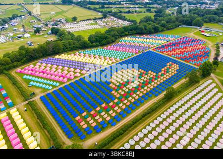 Worthy Farm, Pilton, Somerset, UK.  20th June 2025.  Aerial view of the colourful tents which have been erected in intricate patterns at the Worthy View camp site with a view across the music festival site ahead of the Glastonbury Festival at Pilton in Somerset which starts next week from the 25th June to 29th June 2025.  Picture Credit: Graham Hunt/Alamy Live News Stock Photo
