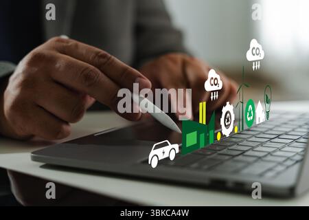 A business sustainability image shows person using stylus digital tablet with various eco friendly and technology icons floating above Stock Photo