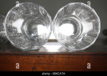 The two transparent drinking glasses placed side by side on a wooden surface, viewed directly from above. The glasses are showcasing their elegance. Stock Photo