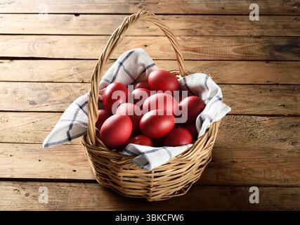 Traditional Greek Easter red dyed eggs in basket on wooden table Orthodox Easter symbol Stock Photo