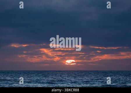 Sun setting over the atlantic ocean in algarve, portugal Stock Photo