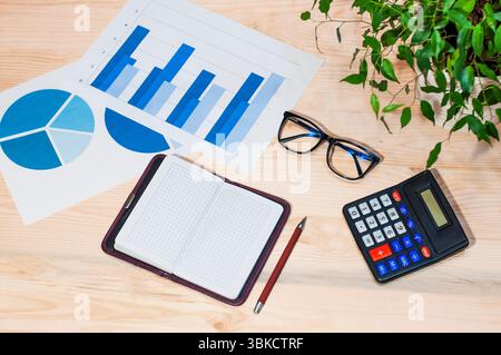 workplace, online work, calculator, glasses, notepad on a wooden table Stock Photo