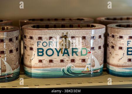 A tin money box in the shape of the famous Fort Boyard stands on a shelf in a shop on Rue Marengo on the island of Aix (Île d'Aix), Charente-Maritime, Nouvelle-Aquitaine, France. It bears the lettering "Fort Boyard", painted windows, a sailing boat and waves, and can be locked with a brass lock and key. The real fort is located on a sandbank between this island and the Île d'Oléron. It gained international fame through the adventure game show "Fort Boyard". The format was adapted in over 33 countries from 1990 onwards. It is considered the most successful French television export, with a huge  Stock Photo