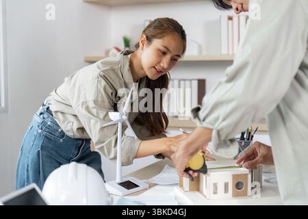 Hands-on Architectural Development. Female architect measuring a model structure. Stock Photo