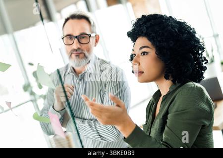 Professional coworkers collaborating on a new project in a creative workspace environment Stock Photo