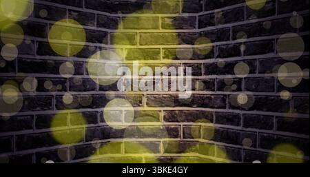 Showing exposed brick wall corner in studio space, with translucent yellow and white light overlays Stock Photo