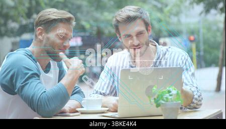 Collaborating colleagues pointing at laptop in street cafe, with coffee cups and security overlay Stock Photo