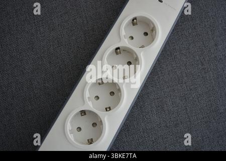 Things, electrical items. New stylish outlet, white stylish extension cords with powerful gray wire, two USB connectors are located on a gray fabric. Stock Photo