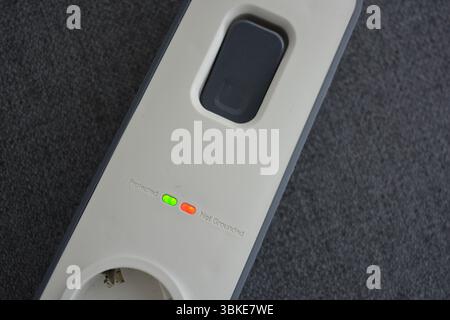 Things, electrical items. New stylish outlet, white stylish extension cords with powerful gray wire, two USB connectors are located on a gray fabric. Stock Photo