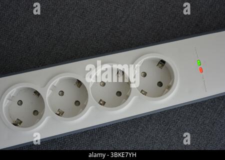 Things, electrical items. New stylish outlet, white stylish extension cords with powerful gray wire, two USB connectors are located on a gray fabric. Stock Photo