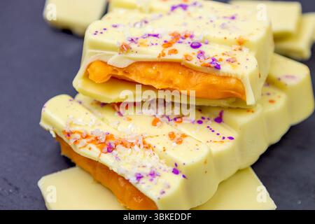 White Mango Dubai Chocolate bar with orange mango, passion fruit spread filling with popping candy close up Stock Photo