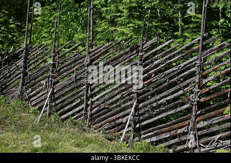 a rustic wooden fence constructed in a traditional Scandinavian style, likely Finnish or Swedish. Made from rough-hewn logs tied together at intersect Stock Photo