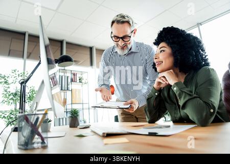 Professional Collaboration Between Diverse Colleagues Engaging in a Productive Office Discussion at a Modern Workspace Stock Photo