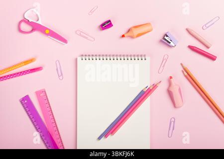 School supplies, marker, pencils, scissors and notepad on pink background. Back to school concept. Flat lay, top view, copy space. Stock Photo