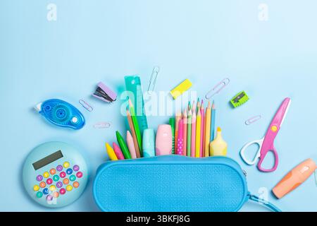 Blue pencil case with school supplies on light blue background. Back to school concept. Flat lay, top view Stock Photo