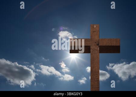 Flat design showing wooden cross standing against blue sky with sun flares, clouds and rainbow arc Stock Photo