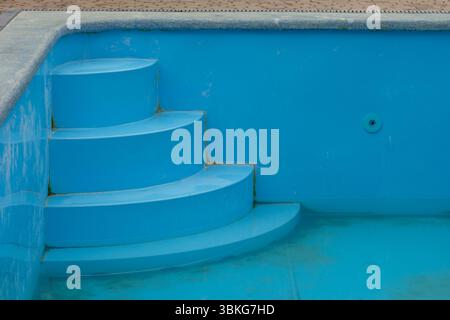 Dirty swimming pool with draining water before cleaning Stock Photo