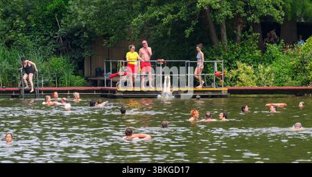London, UK. 21st June, 2025. People swim in a pond of Hampstead Heath in London, Britain, on June 20, 2025. Britain recorded its hottest day of the year on Thursday as an amber heat health alert was issued across England. Credit: Xinhua/Alamy Live News Stock Photo