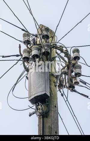 A telegraph pole with wires going to peoples houses giving them phone and wifi connection. Stock Photo