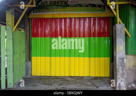 Colorful rolling door with a green stripe and red and yellow stripes. The colors are bright and cheerful, giving the impression of a happy and lively Stock Photo