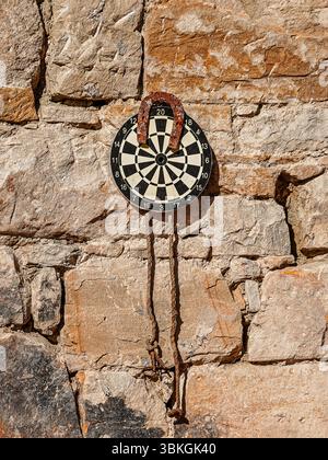 darts game with a horseshoe hanging on the wall Stock Photo