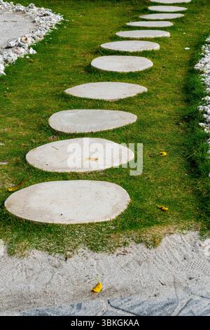 Long path with many small circles on it. The circles are made of concrete and are surrounded by grass Stock Photo