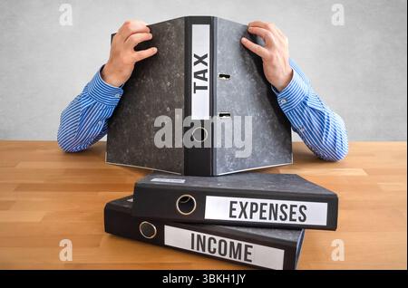 Tax Filing Frustration - Overwhelmed by Paperwork and Deadlines Stock Photo