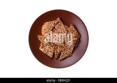 Crispbread, thin bread with seeds and grains, a baked cracker. Crispbread with pumpkin seeds and flax and sesame seeds Stock Photo