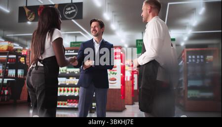 Diverse Team Of Retail Workers Shaking Up Hands In Store. As A Manager, Rewarding Sales Success In Supermarket Business Stock Photo