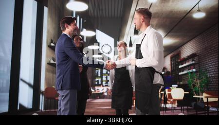 Professional Manager Welcomes Diverse Team With Handshakes In Restaurant Stock Photo