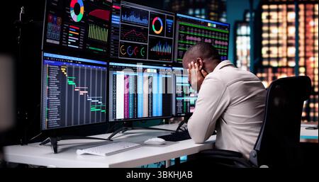 Stressed African American Businessman Working Late On Tax Spreadsheet. Stock Photo