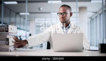 Medical Records Transformation: Young Male Accountant Working On Digital Invoices Stock Photo