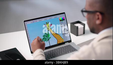 Young African American Photographer Edits Graphic Designs On Laptop In Office. Stock Photo